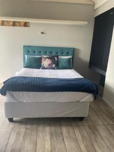 a large bed with a blue headboard in a bedroom at See You There Accommodation in Centurion