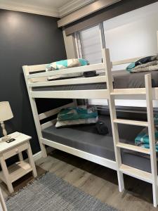1 dormitorio con 2 literas y espejo en Modern Apartment walking distance to Main Beach Restaurants and other amenities, en Jeffreys Bay
