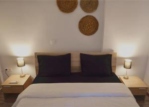 a bedroom with a bed with two night stands and two lamps at Gtrip Gazi Duplex Apartment - 33701 in Athens