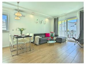 un soggiorno con un divano e un tavolo di Villa Luka Apartment Gray mit Pool a Funtana
