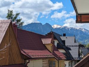 a row of roofs with mountains in the background at Pokoje u Kamińskich 26E in Zakopane