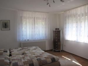 a bedroom with a bed and two windows and a dresser at Feriendomizil Weinheim in Gorxheim