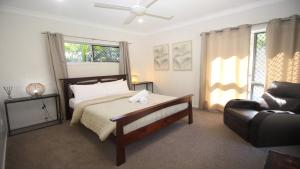 a bedroom with a bed and a chair and a couch at Le Belle Aimante, Magnetic Island in Horseshoe Bay