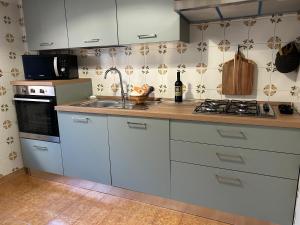 a kitchen with white cabinets and a sink and a stove at La casa di Biba in Bolsena