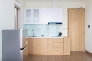 a kitchen with white cabinets and a refrigerator at IN URBAN in Ho Chi Minh City