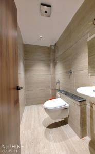 een badkamer met een toilet en een wastafel bij HOTEL 3T WORLD in Nanded