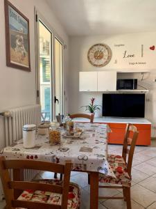 uma mesa e cadeiras numa cozinha com uma mesa e um relógio em Marechiaro em Rimini