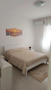 1 dormitorio con 1 cama en una habitación blanca en Le Solite Holiday Rooms, en SantʼEufemia Lamezia