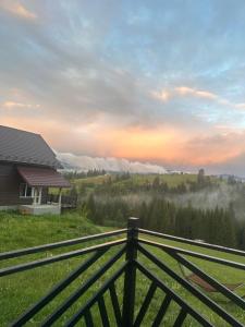 a house on a hill with a fence in the foreground at Мелодія Гір .Апартаменти з видом на гори . in Vorokhta