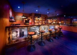 - un bar avec une rangée de tabourets dans une pièce dans l'établissement Hotel Cinema 8, à Schöftland
