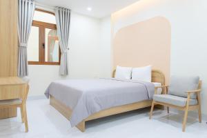 a bedroom with a bed and a chair and a window at IN URBAN in Ho Chi Minh City