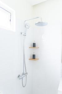 a shower head in a bathroom with a shelf at IN URBAN in Ho Chi Minh City +34 photos