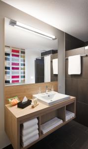een badkamer met een wastafel en een grote spiegel bij Hotel Cinema 8 in Schöftland