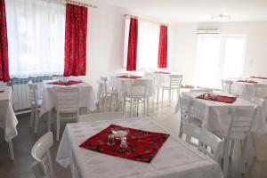 a dining room with white tables and white chairs at Willa pod Granią in Białka Tatrzańska
