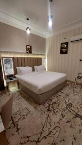 فندق وسام الحوراء في أملج: غرفة نوم مع سرير أبيض كبير في غرفة