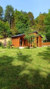a small wooden cabin in a field of grass at Wooden Mountain Villa in Berovo