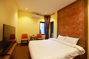 a bedroom with a bed and a table and chairs at Le Grand Hotel HN - by BAY LUXURY in Hanoi +26 photos
