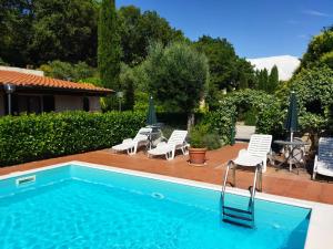 a swimming pool with chairs and a table and a tablektop at azienda agraria Il Cardellino 2 in San Valentino di Villa