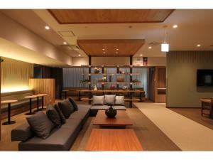 uma sala de estar com um sofá e uma mesa em KAJIMACHI NO YU SPA SOLANI - Vacation STAY 26776v em Hamamatsu