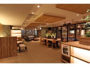 KAJIMACHI NO YU SPA SOLANI - Vacation STAY 26776v في هاماماتسو: غرفة معيشة مع طاولة وكراسي وأريكة