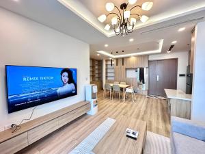 a living room with a large flat screen tv on a wall at Vinhomes Metropolis Hanoi Apartment Hotel in Hanoi