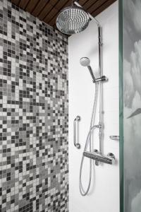 eine Dusche mit Duschkopf im Badezimmer in der Unterkunft Home Hotel Katajanokka in Helsinki + 56 Fotos