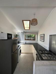 een keuken met een zwart aanrecht en een fornuis bij Cosy Coastal Villa in Lyall Bay in Wellington