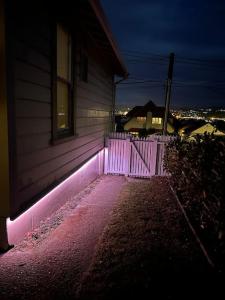 a house with pink lights on the side of it at Cosy Coastal Villa in Lyall Bay in Wellington