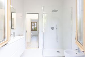 a white bathroom with a shower and a sink at casa panoramica bouganville in SantʼAndrea