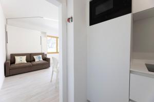 un salon avec un canapé et une télévision dans l'établissement casa panoramica bouganville, à SantʼAndrea