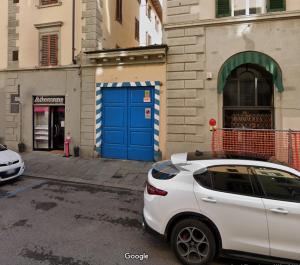 um carro branco estacionado em frente a um edifício com uma porta azul em Savonarola Comfy Flat em Florença