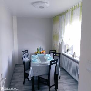 comedor con mesa, sillas y ventana en U Sylwii, en Mikulášovice