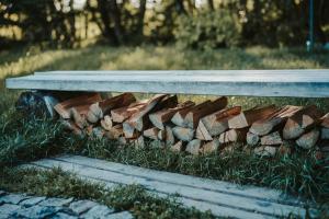 stos drewna opałowego siedzącego obok ławki w obiekcie Treehouse Tučapy w mieście Tučapy