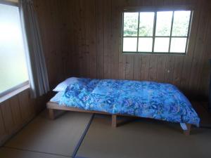 a bedroom with a bed with a blue blanket at SDGs house without bath & shower room - Vacation STAY 34864v in Yufuin