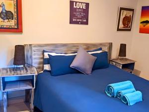 - un lit avec des draps bleus et des oreillers bleus dans l'établissement Zur See - 50m2 Private apartments with Braai - Self catering, à Ballito