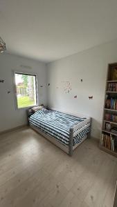 ein Schlafzimmer mit einem Bett und einem Bücherregal in der Unterkunft Maison récente 3 chambres dont 1 suite parentale in Saint-Sauveur-dʼAunis