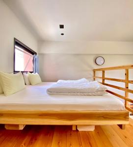 a bedroom with a large bed with a wooden frame at Hotel Little Swiss House in Motobu