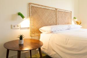 um quarto com uma cama e uma mesa com uma planta em RaíZes 22 - Apartamento 5 em Puebla de Don Fadrique