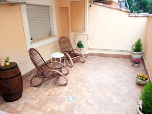 a patio with two chairs and a table and a barrel at as maison in Terni