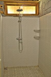 La salle de bains est pourvue d'une douche avec un pommeau de douche. dans l'établissement Dira Bungalows, à Tetebatu