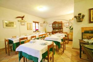 uma sala de jantar com mesas e toalhas de mesa brancas em Agriturismo Barilaro em Finale Ligure
