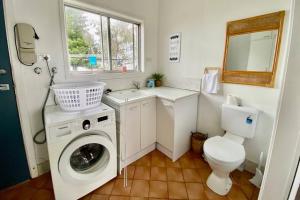 ein Badezimmer mit Waschmaschine und Toilette in der Unterkunft Pet & Family Friendly Ocean Front Beach Cottage in Bargara + 50 Fotos