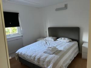 1 dormitorio con 1 cama con edredón blanco y ventana en Villa Nybro, en Nybro