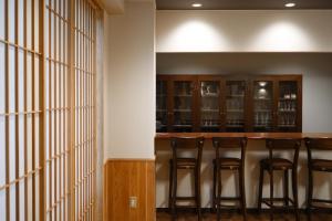 a bar in the basement of a home with stools at Hotel Bauhinia in Shinano