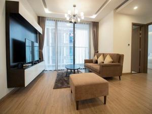 a living room with a couch and a tv at Vinhomes Metropolis Hanoi Apartment Hotel in Hanoi