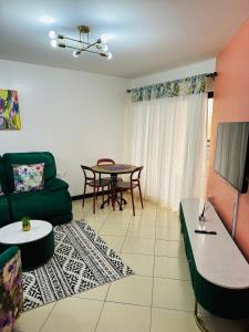 a living room with a green couch and a table at Cozy Retreat Near Nairobi National Park, Giraffe Centre & Wilson Airport in Nairobi