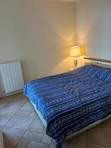 een bed in een kamer met een blauwe deken erop bij Traum-Balkon mit Panoramablick und Pool am Lago Maggiore in Oggebbio +20 foto's