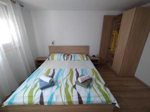 a bedroom with a bed with towels on it at Apartman Tri palme in Gabonjin
