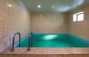 a bathroom with a large blue tub with two faucets at Apartamentai Laima in Druskininkai