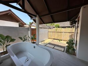 y baño con bañera blanca y jardín. en Chumphon Cabana Resort en Chumphon